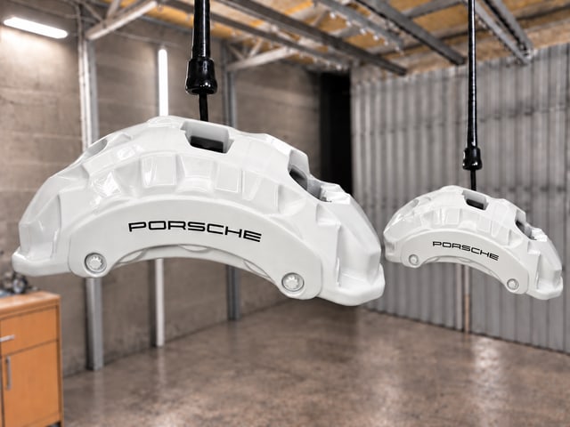 Белые суппорты Porsche на подвесах, крупный план под углом